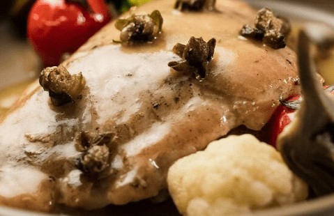 Pescado con salsa, tomate, alcauciles y brócoli blanco.