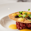 Tartar de atún con crujiente, hierbas frescas y salsas de diferente tipo.
